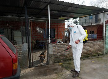 A worker disinfects an area