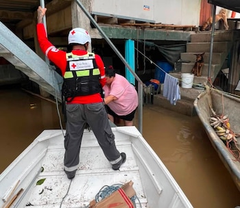 Un voluntario de la Cruz Roja Costarricense asiste a una persona afectada por las inundaciones, durante labores de evacuación en una comunidad anegada por las lluvias (Cortesía: Cruz Roja).