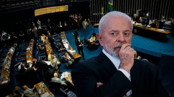 Lula da Silva en primer plano, con barba blanca y traje oscuro, sujetando su barbilla, sobre un fondo borroso del interior del Congreso de Brasil.