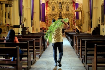 AME8166. TEGUCIGALPA (HONDURAS), 27/03/2026.- Un hombre camina con ramos de palma este viernes, dentro de la Catedral San Miguel Arcángel previo a la celebración del Domingo de Ramos, en Tegucigalpa (Honduras). EFE/ Gustavo Amador
