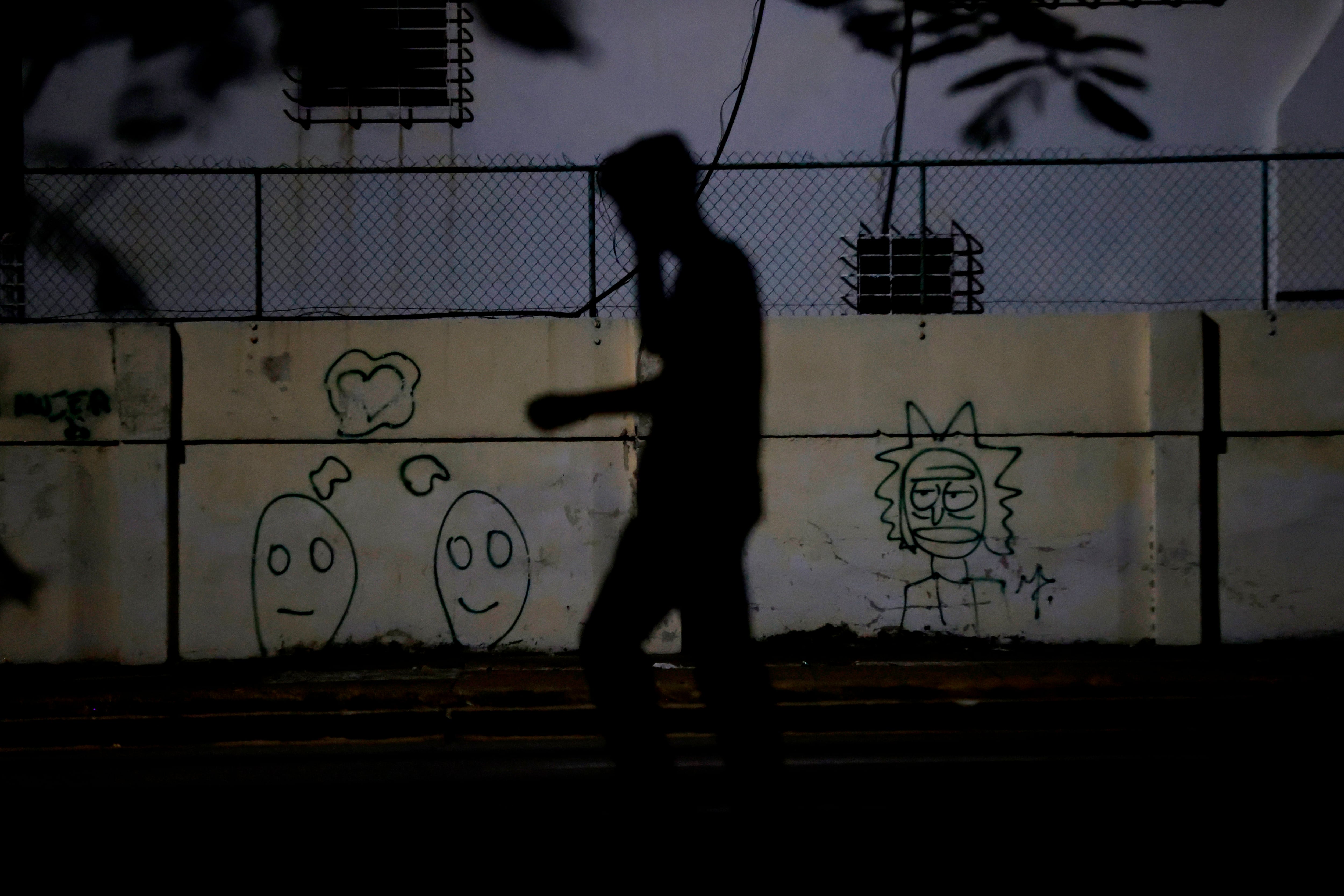 Fotografía de archivo de un transeúnte al caminar en medio de una calle en penumbra, durante uno de los diarios cortes de energía eléctrica, en La Habana (Cuba). EFE/Ernesto Mastrascusa