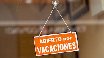 Cartel 'abierto por vacaciones'. (Montaje