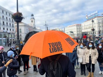 FOTO DE ARCHIVO: Un guía turístico con un paraguas se dirije a un grupo de turistas con mascarilla en la Puerta del Sol de Madrid, España, el 22 de enero de 2022. REUTERS/Nacho Doce