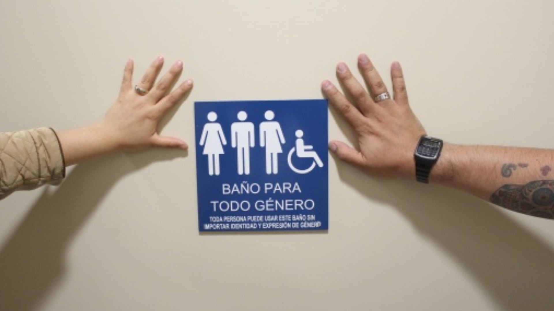 Manos enmarcan un letrero azul de