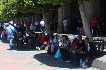 Personas sentadas mientras se cubren