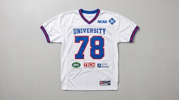 Camiseta blanca de fútbol americano con el número 78, la palabra University y emblemas de la NCAA y marcas comerciales.