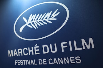 Primer plano de un cartel azul oscuro con el logo blanco del Festival de Cannes, que incluye la hoja de palma, y el texto "Marché du Film" y "Festival de Cannes"