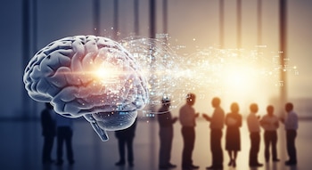 Primer plano de un cerebro humano estilizado con luz brillante y líneas digitales que emanan de él, sobre un fondo borroso de siluetas de personas interactuando.