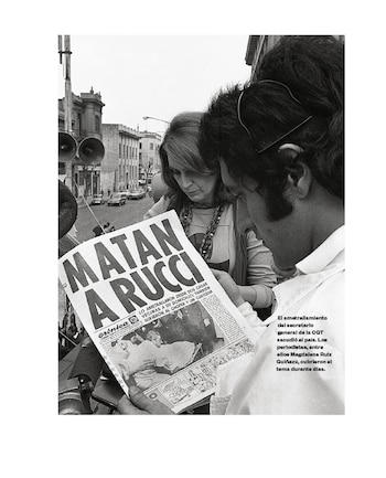Fotografía en blanco y negro muestra a dos personas, un hombre y una mujer, de perfil, inclinadas sobre un periódico con el titular "MATAN A RUCCI"
