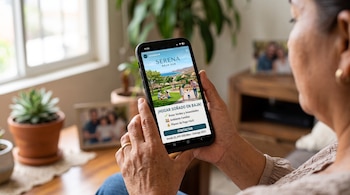 Manos de una mujer sosteniendo un teléfono móvil que muestra una publicidad inmobiliaria con texto e imágenes de un parque.