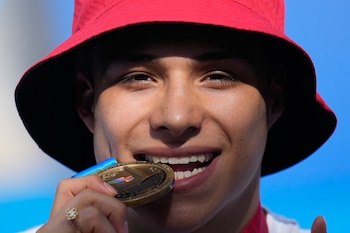 El mexicano Osmar Olvera muerde su medalla de oro durante la premiación del trampolín de 3 metros de los Juegos Centroamericanos y del Caribe, el sábado 1 de agosto de 2026, en Santo Domingo. (AP Foto/Fernando Vergara)