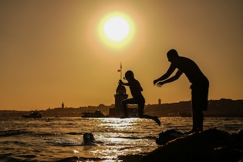 Personas saltan al Bósforo en Estambul el 28 de junio de 2026. Europa es el continente que más rápido se calienta en la Tierra, según advirtió la OMS ante la ola de calor. (AP Foto/E. Gurel)