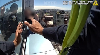Vista desde una cámara corporal de un oficial de policía extendiendo la mano hacia una persona con el rostro pixelado al borde de un rascacielos