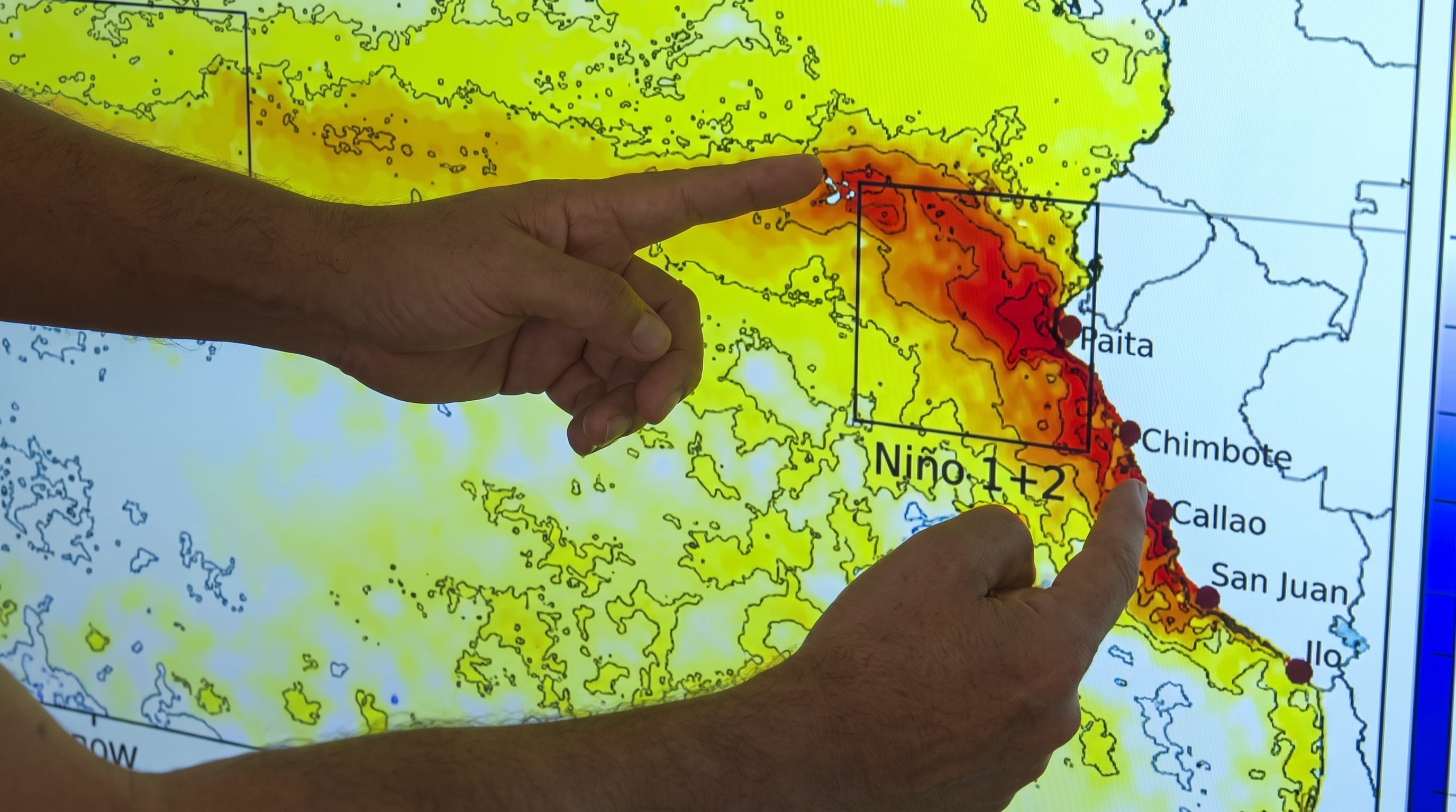 Dos manos señalan un mapa que indica las anomalías de temperatura de la superficie del mar frente a la costa de Perú, asociadas al fenómeno El Niño. (Senamhi)