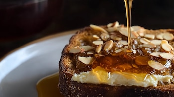 Pan integral crujiente, miel artesanal, queso vegetal, desayuno nutritivo, tostadas saludables, combinación natural y equilibrada. - (Imagen Ilustrativa Infobae)