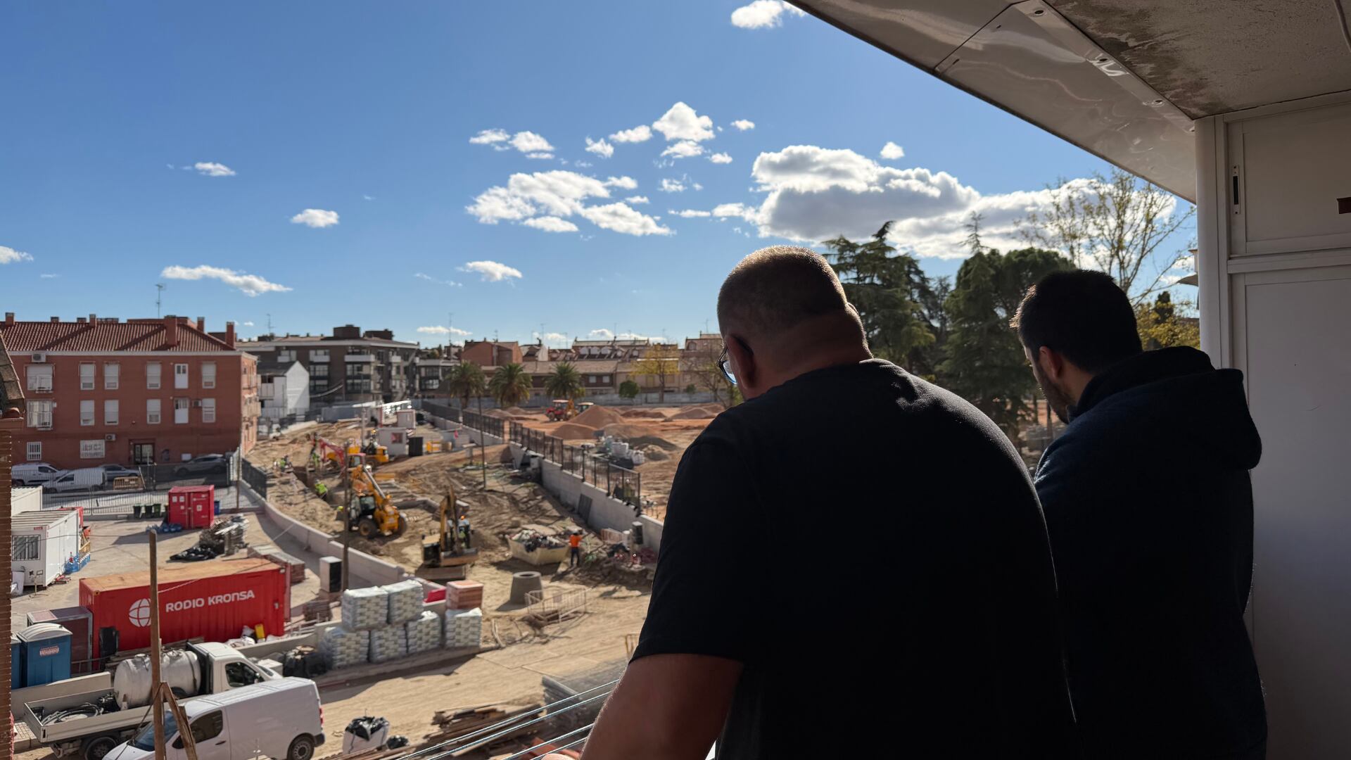 David Casado (i) y Alejandro Escribano (d) observan las obras de reconstrucción tras los derribos de 73 viviendas en San Fernando, Madrid. (Lydia Hernández Téllez/Infobae España)