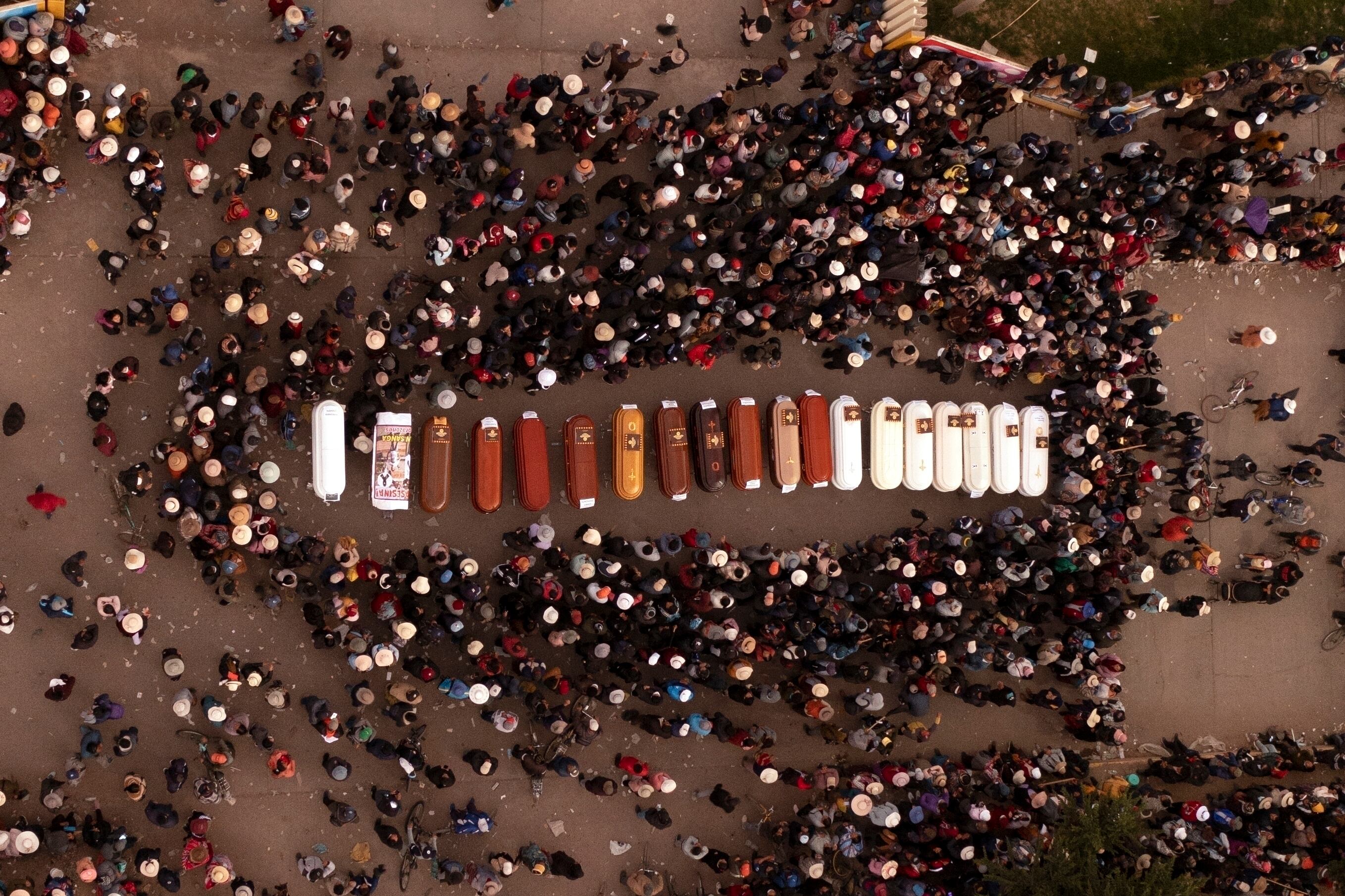 ARCHIVO - Los residentes rodean los ataúdes durante una vigilia por las más de una docena de personas que murieron durante los disturbios en Juliaca, Perú, el martes 10 de enero de 2023. Grupos de derechos humanos, incluida la ONU, han pedido al gobierno peruano que investigue denuncias de uso excesivo de la fuerza por parte de policías y soldados durante las recientes protestas que han dejado 49 civiles muertos. (AP Foto/Jose Sotomayor, Archivo)