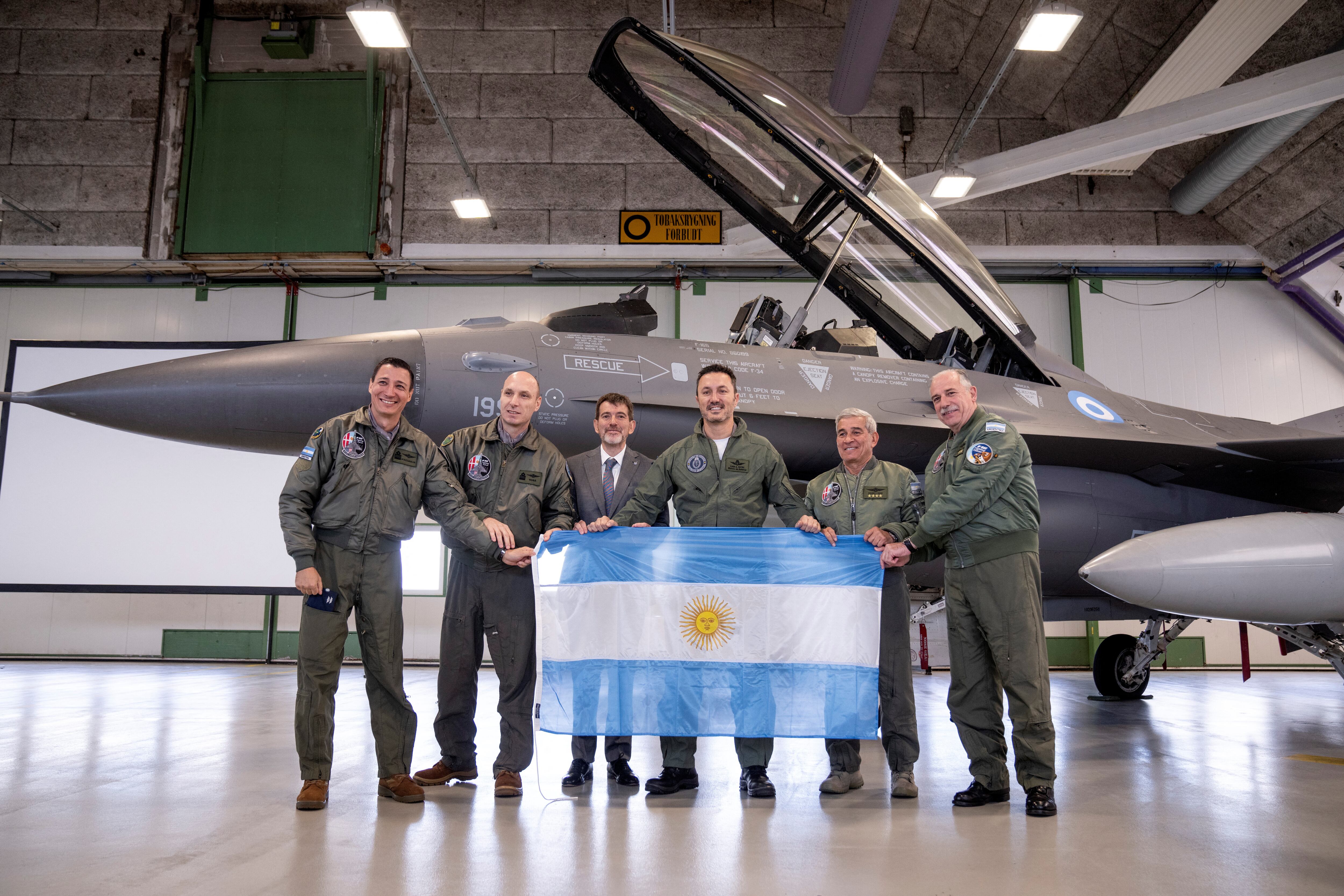 El ministro de Defensa Luis Petri posa con la bandera argentina en Dinamarca, donde el país compró 24 aviones F16
