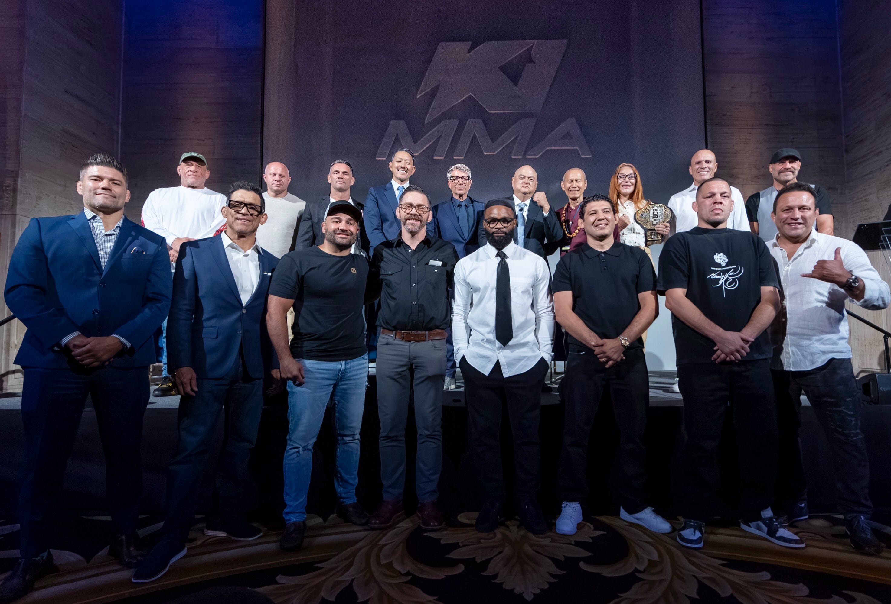 Dirigentes y peleadores de artes marciales mixtas, entre ellos Scott Coker, Fedor Emelianenko y Randy Couture, se reúnen durante un evento (@ki_mmaofficial)