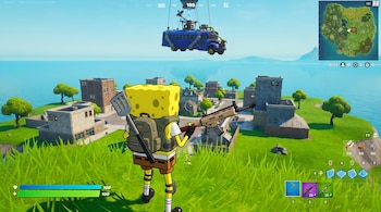 Personaje de Bob Esponja en Fortnite, con mochila, espátula y rifle. Se ve un entorno de juego con edificios, césped, mar y el autobús de batalla en el aire.