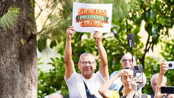 Algunos mexicanos que residen en España llevaron carteles a la convivencia con la presidenta de México. (Foto: Presidencia)
