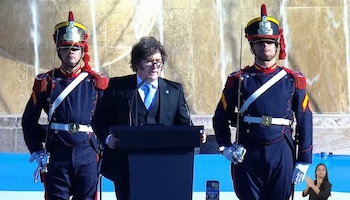 El presidente Javier Milei pronuncia un discurso desde un atril durante un acto en la ciudad de Rosario, flanqueado por dos guardias militares.