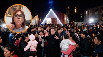 Sacerdote y feligreses reunidos frente a una iglesia iluminada de noche, con Magaly Medina en un círculo en la esquina superior izquierda.