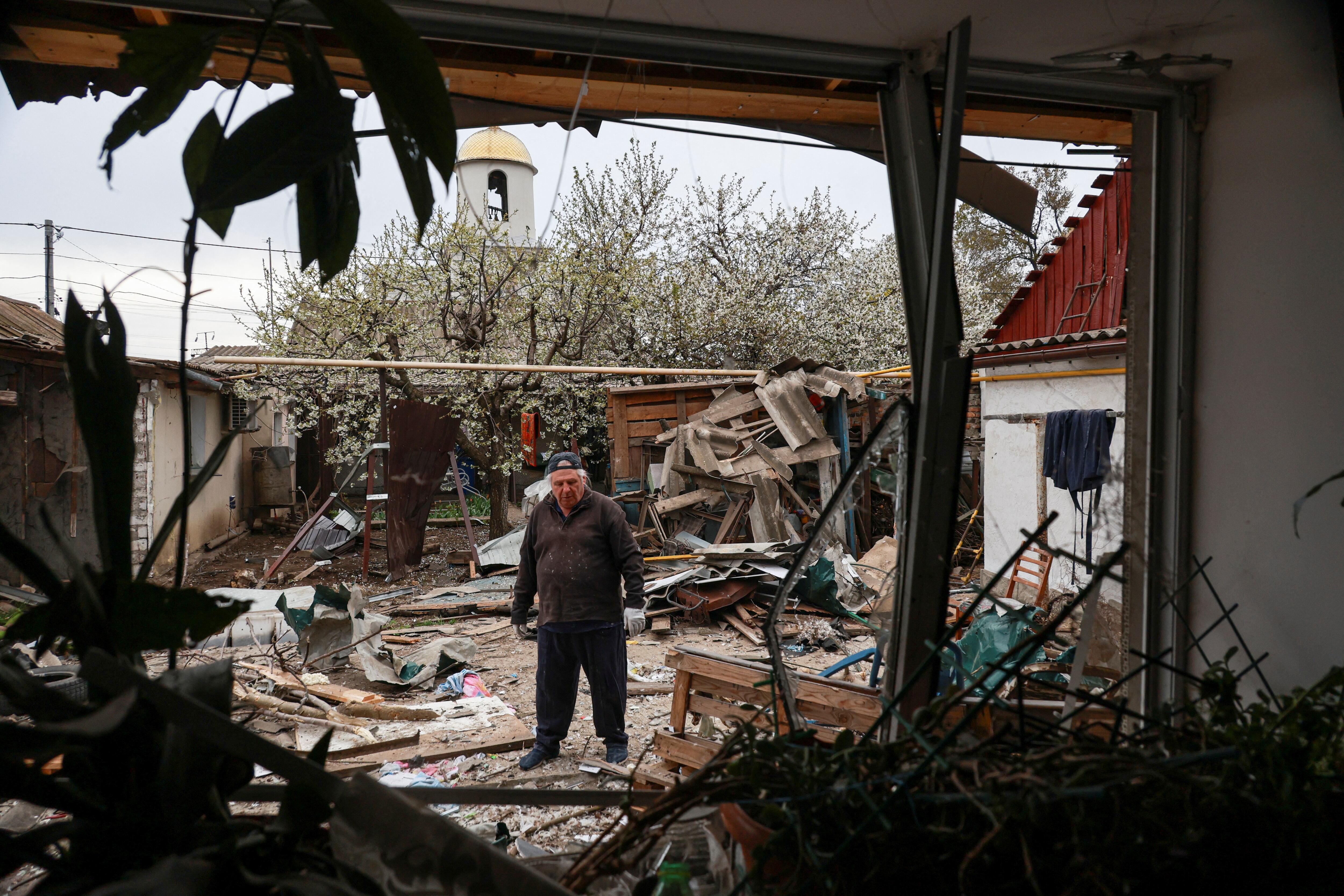 Un residente de pie en un patio trasero de su casa dañada durante un ataque de aviones no tripulados rusos, en medio del ataque de Rusia contra Ucrania (REUTERS/Nina Liashonok)