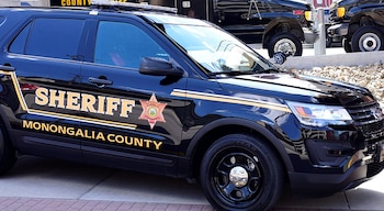 Vehículo policial negro con la palabra SHERIFF y el texto MONONGALIA COUNTY en letras doradas en la puerta