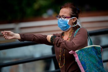 Ciudadanos caminan con tapabocas por