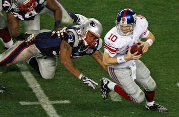 FILE PHOTO: New York Giants quarterback Eli Manning (10) avoids a sack by New England Patriots end Richard Seymour (L) in the fourth quarter of the NFL's Super Bowl XLII football game in Glendale, Arizona February 3, 2008. REUTERS/Jeff Topping (UNITED STATES)/File Photo