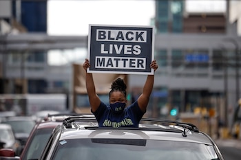 A person holds a placard out of a car's sunroof after the verdict in the trial of former Minneapolis police officer Derek Chauvin, found guilty of the death of George Floyd, in front of Hennepin County Government Center, in Minneapolis, Minnesota, U.S., April 20, 2021. REUTERS/Carlos Barria
