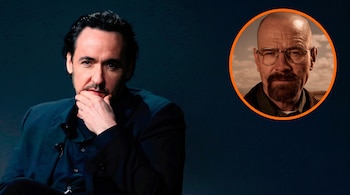 El actor John Cusack apoyando la mano en su barbilla junto a un círculo naranja con la cara del personaje Walter White.