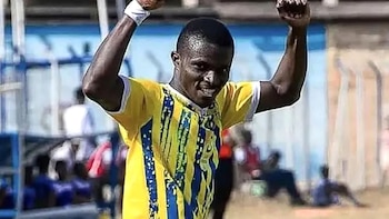 Dominic Frimpong, un futbolista con camiseta a rayas amarillas y azules, celebra con los brazos en alto y los puños cerrados en un campo deportivo