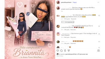 Dos niñas posan con un ramo de flores, un sobre blanco y un cheque gigante de color rosa con el nombre de Brianna Cuadros López