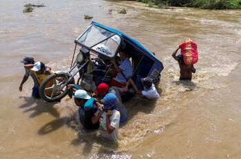 Residents carry a motorcycle taxi