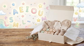 Caja abierta sobre madera con ropa de recién nacido, botines y cubos con letras, junto a un fondo con letras y estrellas ilustradas.