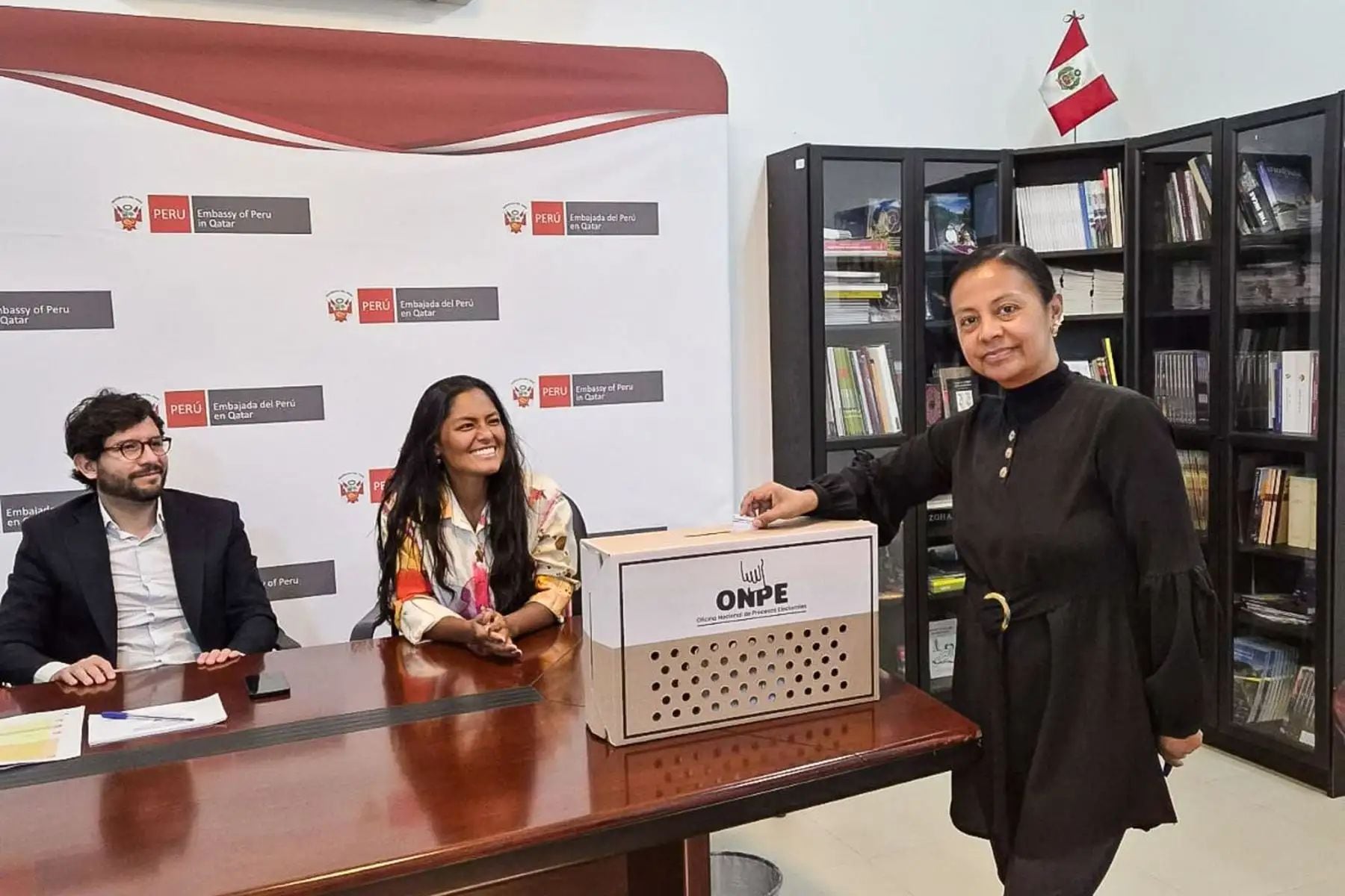 Una mujer peruana deposita su voto en la urna de ONPE en la Embajada de Perú en Qatar, mientras funcionarios observan el proceso de la segunda vuelta electoral. (Agencia Andina / Cancillería)