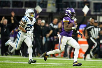 El corredor de los Vikings de Minnesota Dalvin Cook avanza frente al safety de los Colts de Indianápolis Rodney McLeod en una recepción de 64 yardas para touchdown en el encuentro del sábado 17 de diciembre del 2022. (AP Foto/Abbie Parr)