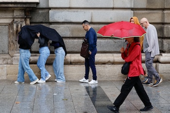 Numerosas personas que se protegen de la lluvia con paraguas en el Palacio Real de Madrid, imagen de archivo. (EFE/ Mariscal)