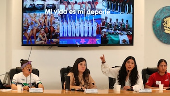 Cuatro mujeres en un panel con micrófonos. Una de ellas señala una pantalla grande con fotos de atletas y la frase 'Mi vida es mi deporte'. A la derecha, el escudo nacional de México