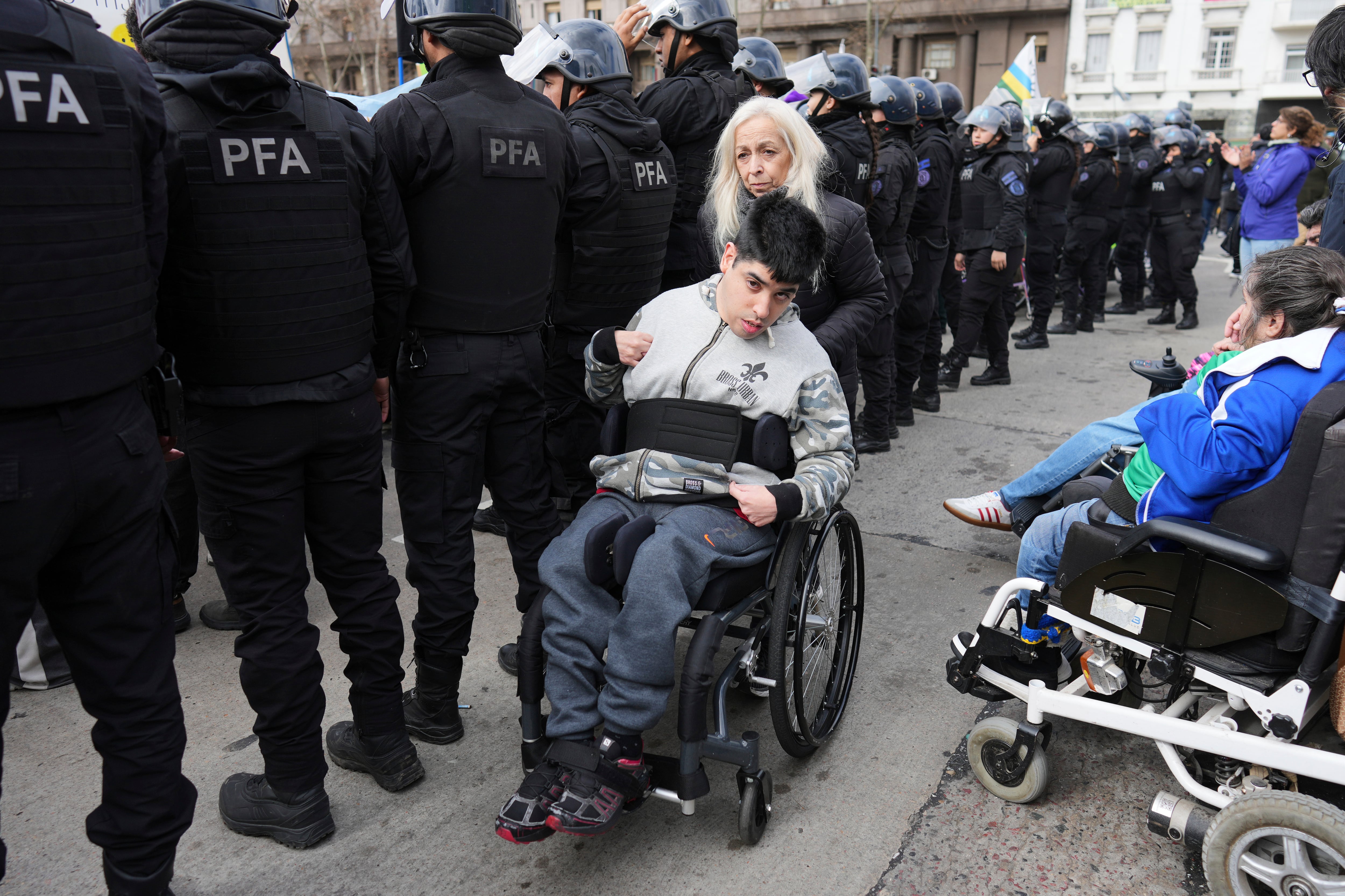 Manifestantes participan en una protesta contra el veto del presidente Javier Milei a un proyecto de ley aprobado por el Congreso para aumentar el gasto en pensiones y ampliar la protección de las personas con discapacidad, en Buenos Aires, Argentina, el martes 5 de agosto de 2025. (AP Foto/Rodrigo Abd)