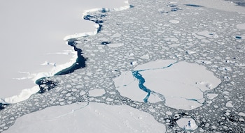 Foto aérea del mar de Weddell mostrando una vasta extensión de hielo marino blanco fragmentado y placas de hielo, intercalado con zonas de agua azul oscuro y charcas de deshielo claras.