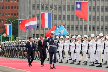 El presidente de Paraguay, Santiago Peña (centro), y su homólogo de Taiwán, Lai Ching-te (izquierda), pasan revista a una guardia de honor militar durante una ceremonia de bienvenida en Taipéi, Taiwán, el 8 de mayo de 2026. (AP Foto/Chiang Ying-ying)