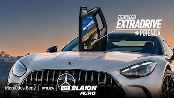 Un envase de lubricante YPF Elaion Auro sobre el capó de un automóvil gris de marca Mercedes-Benz frente a montañas