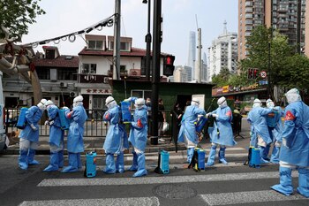 Workers in protective suits prepare