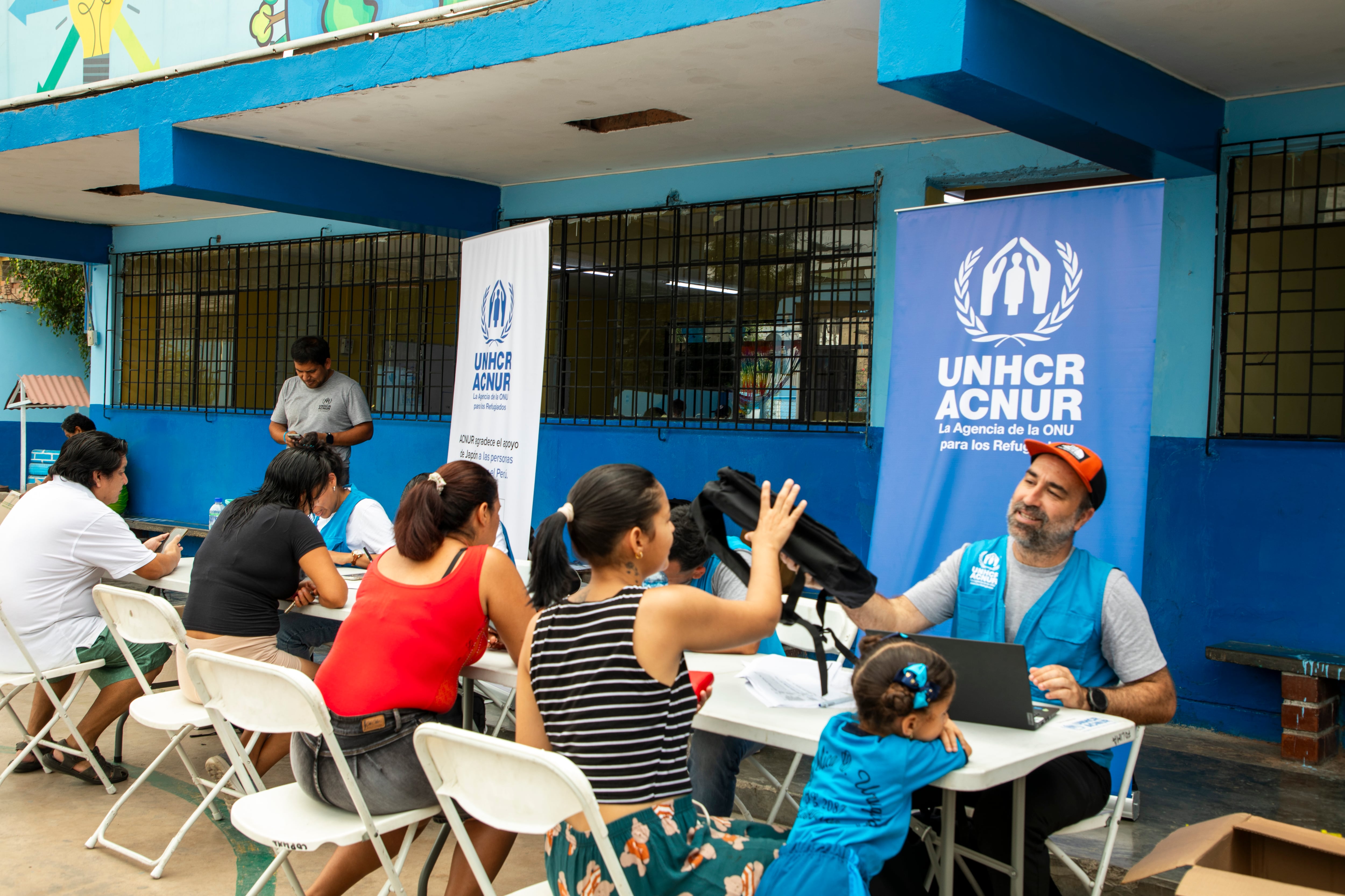 Representantes de ACNUR ofrecen asistencia y orientación a familias en una cafetería comunitaria en Perú, con el apoyo del gobierno de Japón. (ONU Perú)