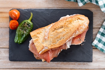 Receta de serranito, un bocadillo clásico a base de lomo, jamón serrano, pimiento verde y tomate (Magnific)
