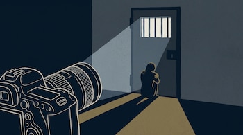 Ilustración de una cámara de fotos a la izquierda que ilumina a una persona sentada en el suelo frente a una puerta de celda.