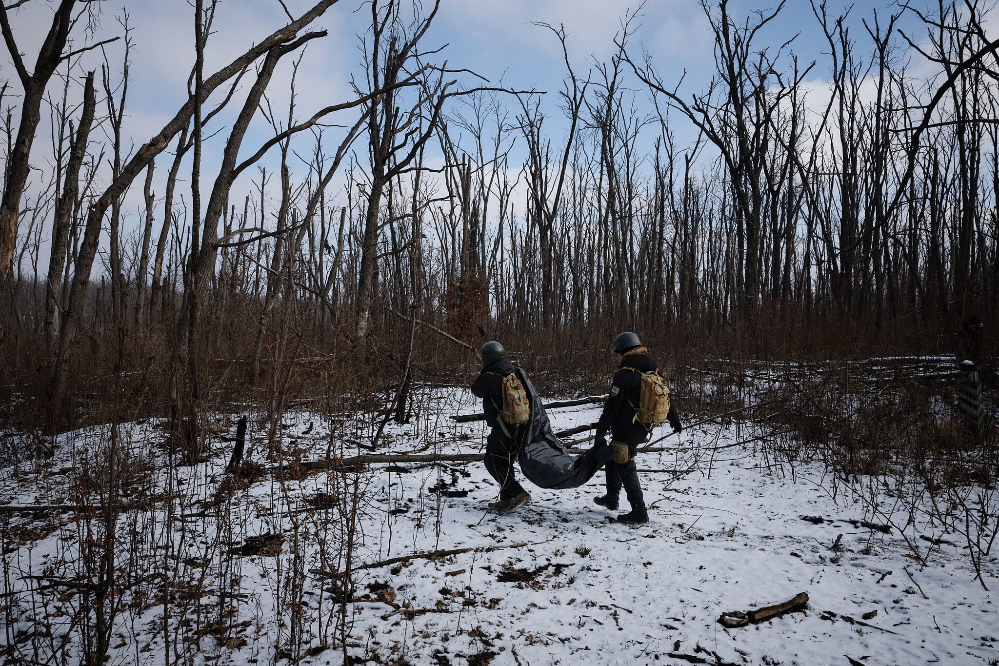 Voluntarios ucranianos recogieron los restos de soldados rusos en un campo de batalla en la región de Járkov, en el este de Ucrania, en febrero (Tyler Hicks/The New York Times)
